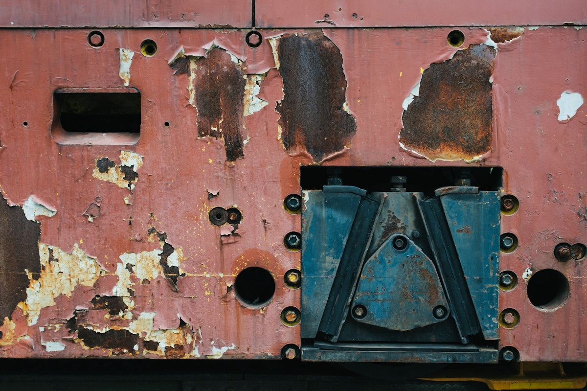 a rusted metal structure with holes and rivets