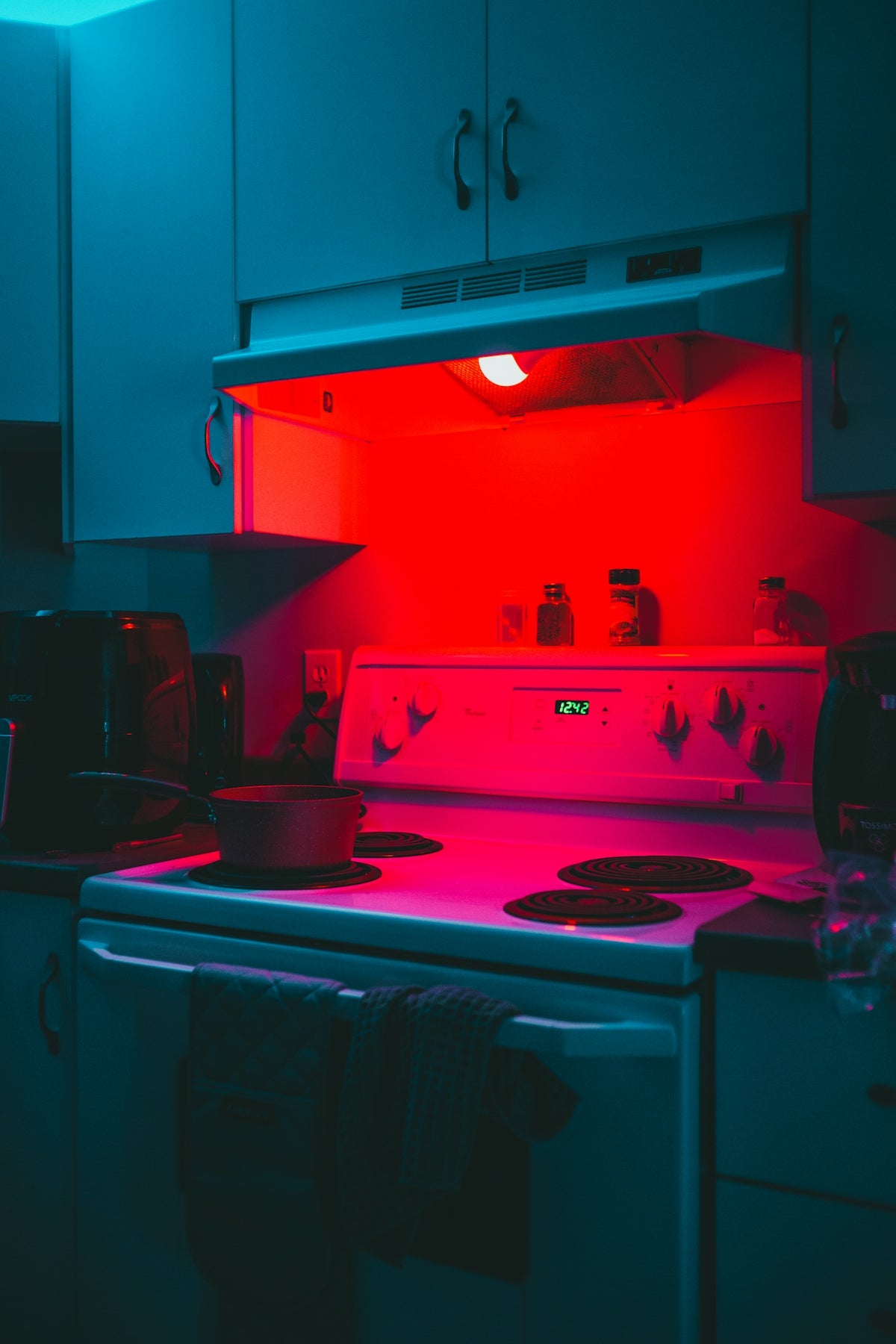 a kitchen with a stove top oven under a red light