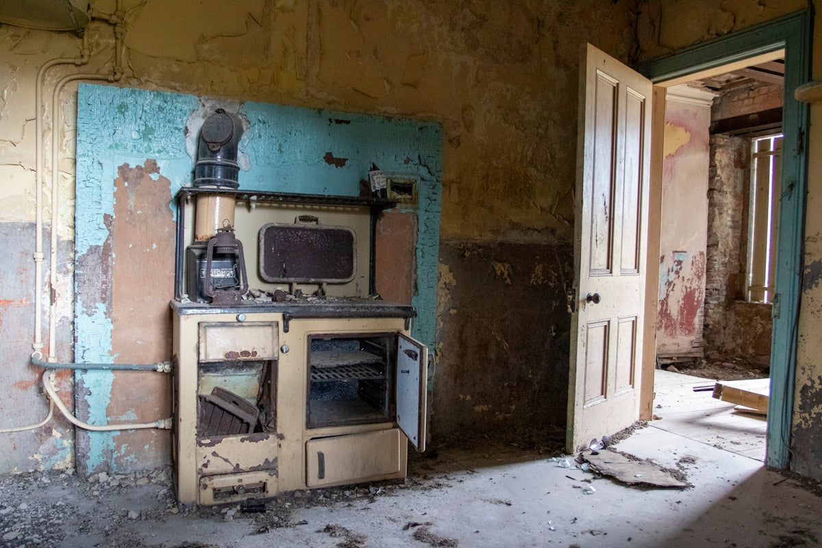 an old stove and oven in a run down room