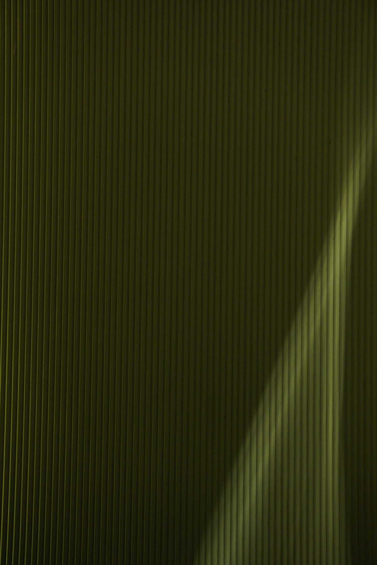 a green wall with a light shining on it