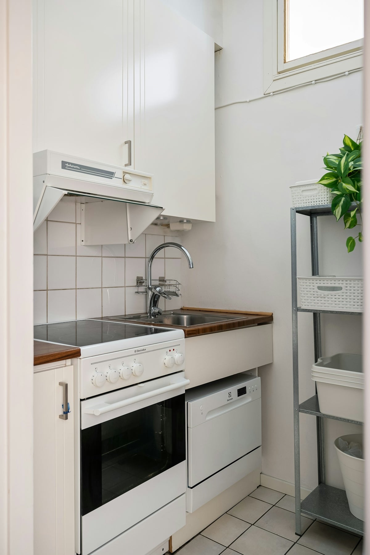 A kitchen with a sink, stove, and dishwasher