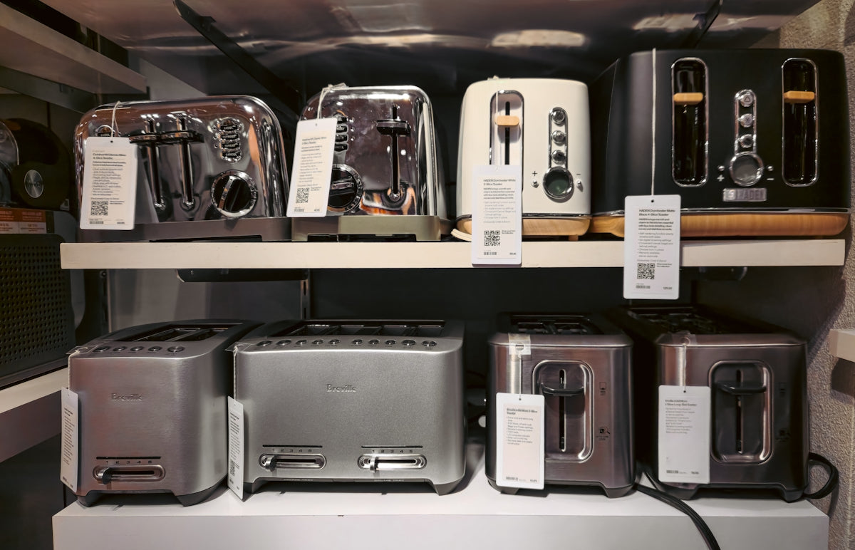 A bunch of toasters that are on a shelf