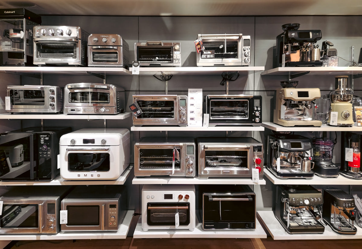 A bunch of microwaves that are on a shelf