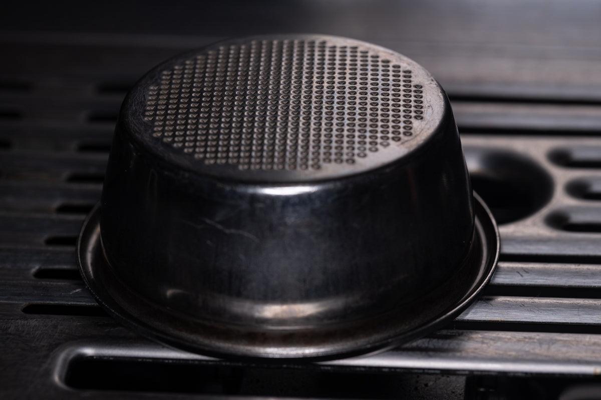 An espresso machine's filter basket is visible.