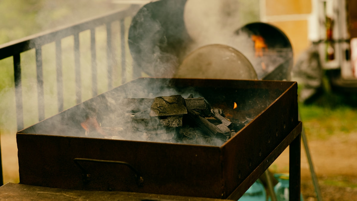Smoke rises from a barbecue grill.