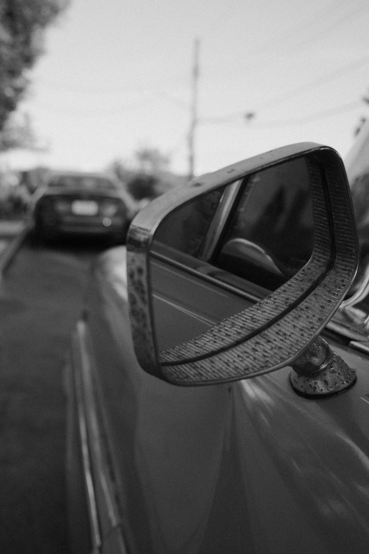 Car's side mirror showing a reflection of a car.