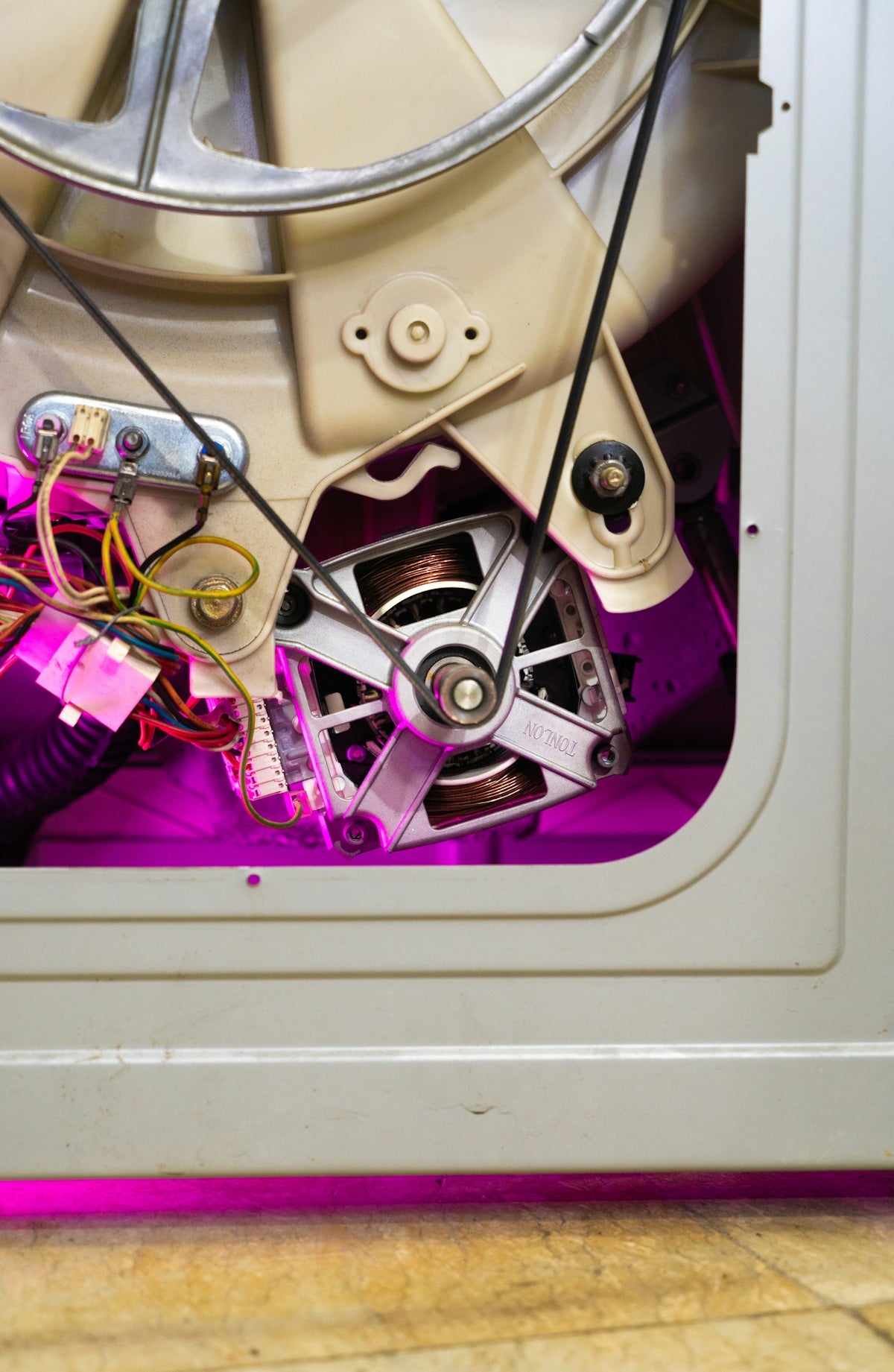 Close-up of washing machine motor and belt mechanism