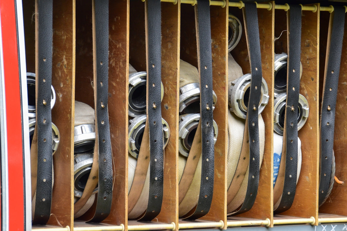 Multiple fire hoses neatly stored in compartments.