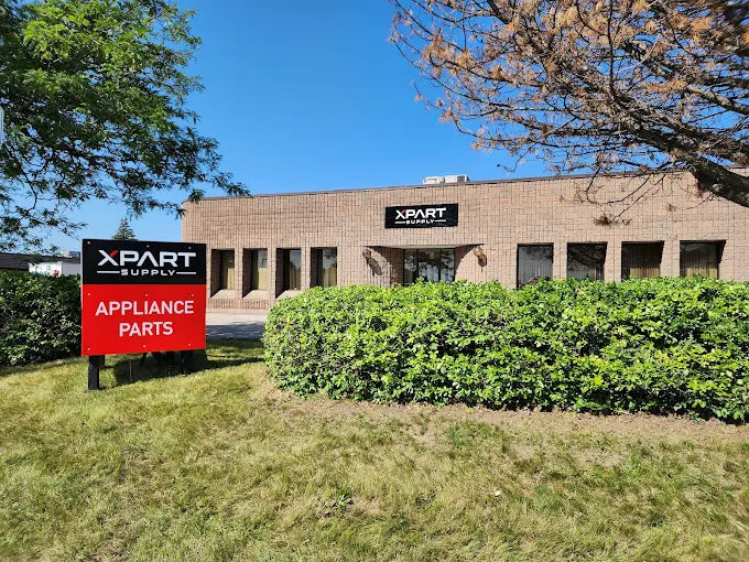 Xpart Supply building with a sign for appliance parts on a clear day.