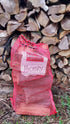 BBQ grill wood log bundles in red mesh bags labeled Hickory stacked outdoors with firewood
